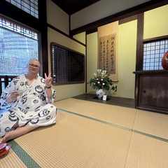 Me sitting on a tatami floor dressed in a robe at Dogo Onsen.