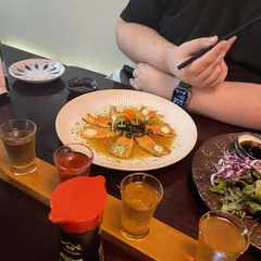 Salmon tataki. Small, thin slices of salmon sitting on a plate arranged like a flower.