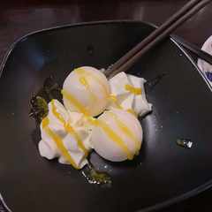 Yukimi daifuku, mochi balls with ice cream inside, with a drizzle of mango sauce.