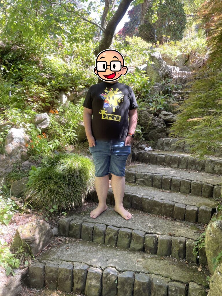 Feets stands on gravel steps, surrounded by lush, green plantlife