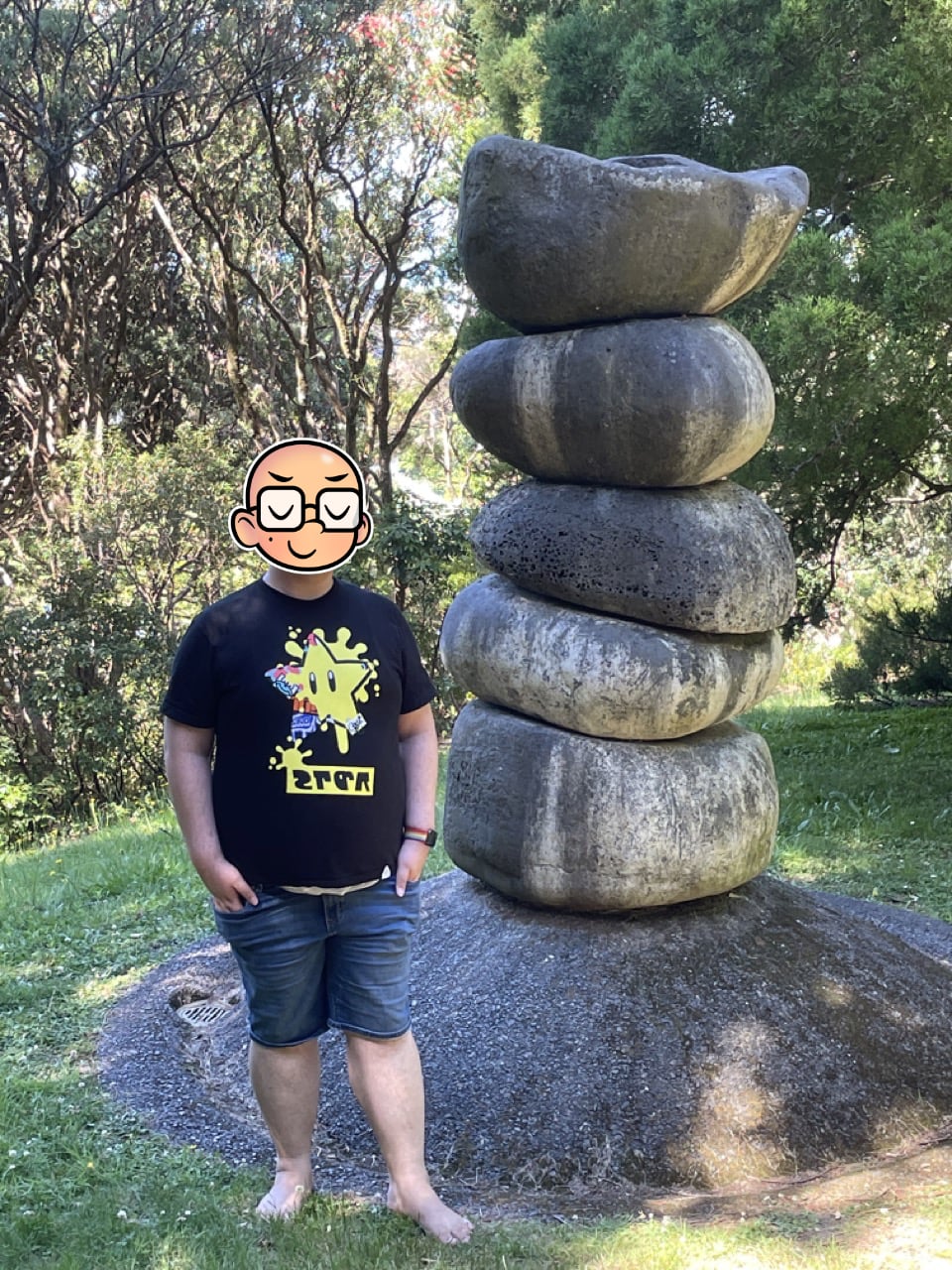 Feets stands next to a stack of large rocks piled on top of each other